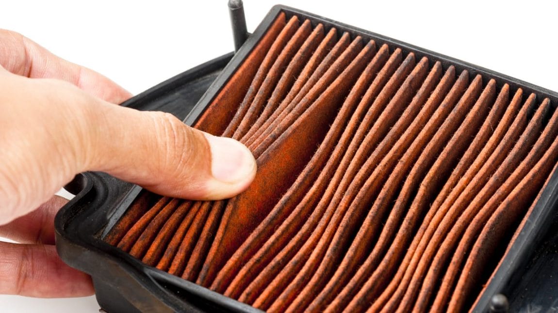 The image shows a clogged air filter that restricts the flow of clean air