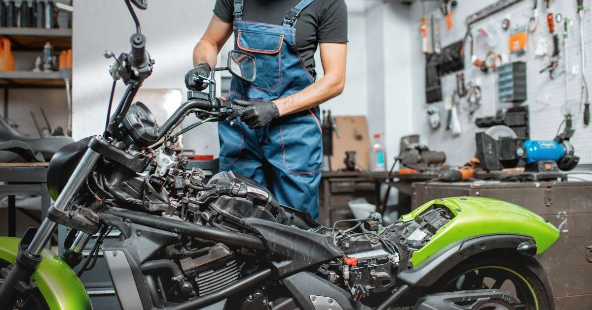 Motorcycle mechanic working on a bike in a garage 